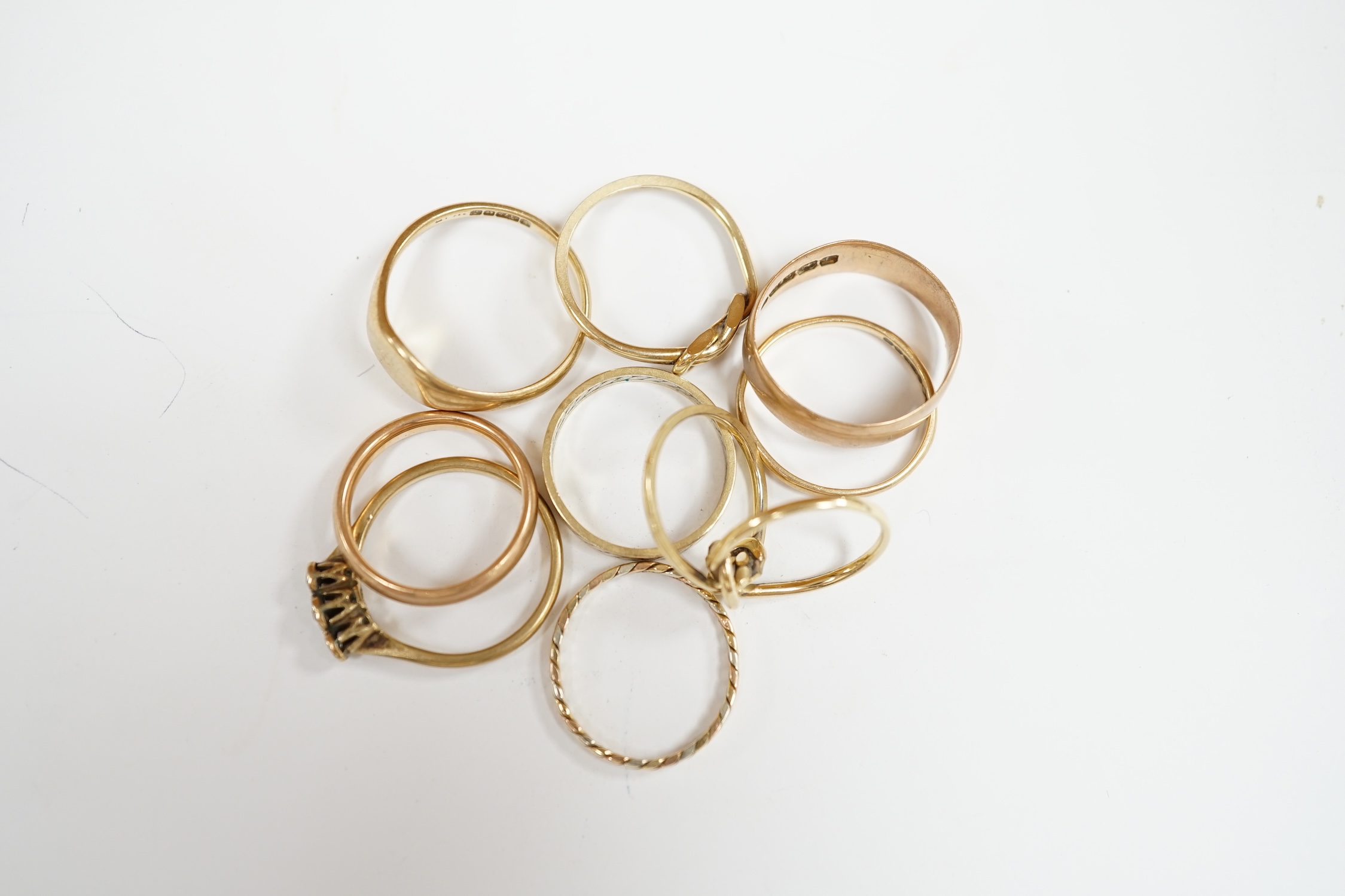 Six assorted 9ct gold bands, including two colour, together with a 9ct gold signet ring, a double band 9ct ring and a 9ct and three stone gem set ring, gross weight 18.8 grams. Condition - poor to fair